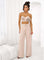 Woman wearing a beige crop top with large 3D floral appliqués and spaghetti straps