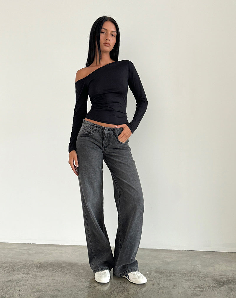 Woman wearing low-rise washed black-grey jeans with straight leg fit and white sneakers